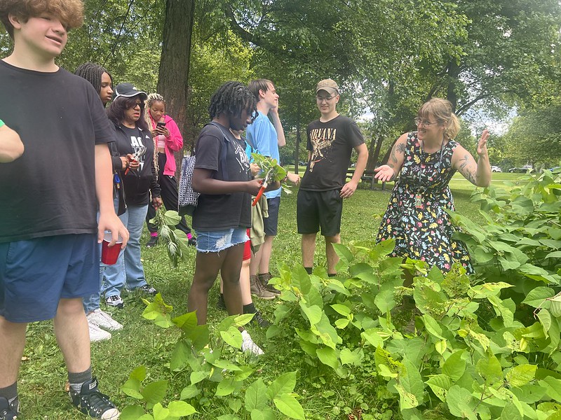 Photo of youths and BOPC employee at Cazenovia Park, surrounded by greenery
