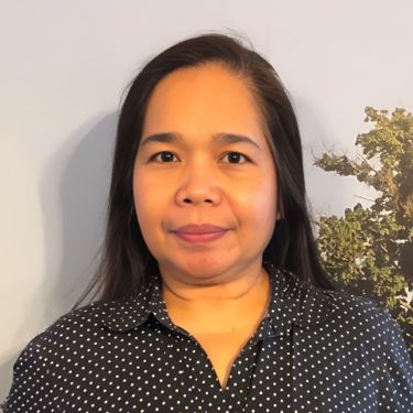 Gleanie wearing a polka dot shirt against a photo backdrop of the park