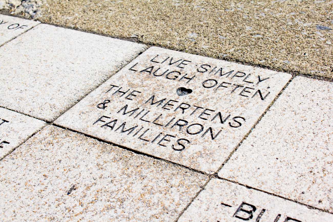 Brick paver with text engraved "Live Simply, Laugh Often, The Mertens and Milliron Families"