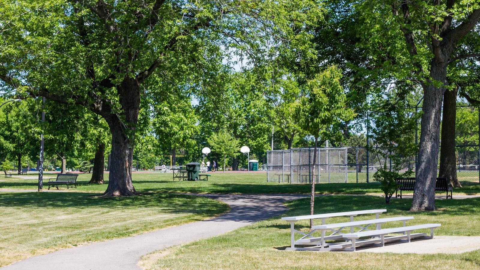 Trees and pathway at Riverside Park with athletic fields in the background